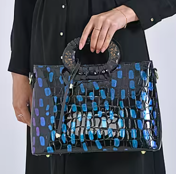 Blue round crossbody bag with dual handles and faux-crocodile texture.